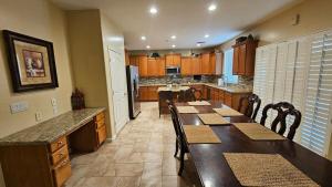 a large kitchen with a long table and chairs at Spacious 5-bedrm home 3 min from Cardinals Stadium in Phoenix