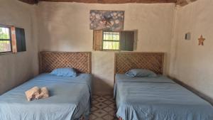 two beds in the corner of a room at cabañas Chulin Ha in San Benito