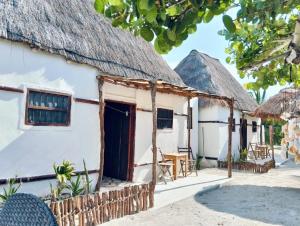 a house with a thatched roof and a patio at cabañas Chulin Ha in San Benito