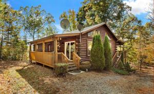 a log cabin in the woods with a front porch and stairs at Cedar Ridge in Mill Spring