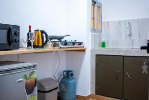 una piccola cucina con fornelli e piano di lavoro di Green Haven - Modern Cozy Studio - Fast Wi-Fi - AC - Cocody a Abidjan Altre 4 foto