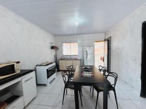 a kitchen with a table and chairs and a refrigerator at Casa em Aurora do Tocantins in Manhã