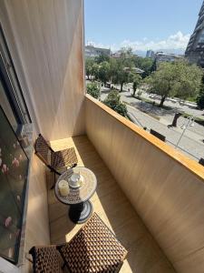 a balcony with a table and chairs and a window at Шелковый Путь Премиум in Almaty