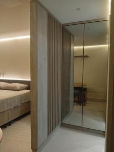 a bedroom with a bed and a glass wall at Flat Vert House in João Pessoa +12 photos