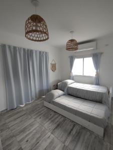a bedroom with a bed and two pendant lights at Casa con Jardín Las Marías 2 in Miramar