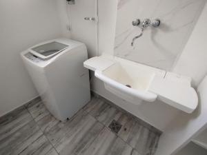 a white bathroom with a toilet and a sink at Casa con Jardín Las Marías 2 in Miramar +12 photos