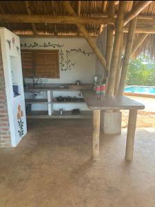 Cette chambre comprend une table en bois et une cuisine. dans l'établissement Casa Akasha, à Mingueo