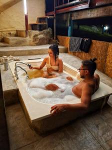 a man and a woman sitting in a bath tub at Glamping el Porvenir RNT 10601 in Manta