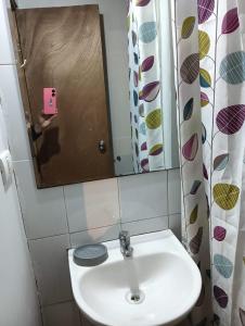 Un baño con un lavabo blanco y un espejo. en Cabaña Claudia Espinoza, en Villarrica 1 foto más