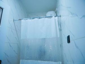 a shower with a white shower curtain in a bathroom at LV-21 Service Apartment MO4a in Lagos +31 photos