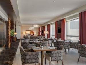 a dining room with tables and chairs in a restaurant at Swissôtel Al Ghurair Dubai - Deira & Creek in Dubai