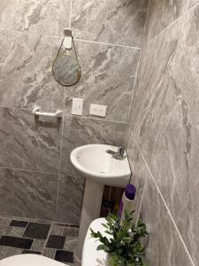 a bathroom with a sink and a toilet and a mirror at Habitación 1 persona cerca de aeropuerto,terminal de buses y estadio in Soledad