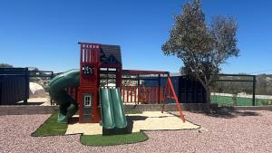 a park with a playground with a slide and a slideintend at Cabañas aldebaran cienega redonda in Hechicera