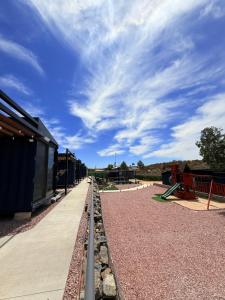 an empty playground with a blue sky and clouds at Cabañas aldebaran cienega redonda 