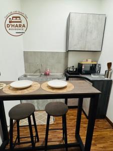 una cocina con una mesa y dos taburetes en K Avenue By D Hara Residence, en Kota Kinabalu