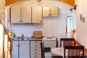 a kitchen with white cabinets and a sink at Apartments by the sea Stari Grad, Hvar - 22052 in Stari Grad