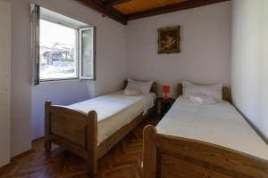 two beds in a room with a window at Apartments by the sea Stari Grad, Hvar - 22052 in Stari Grad