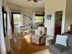 a living room with a couch and chairs and a table at Avocado House in Naalehu