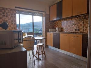a kitchen with a microwave and a table and chairs at Seia Flat Mountain Seia View in Seia