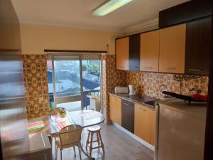 una cucina con un tavolo e un piano di lavoro di Seia Flat Mountain Seia View a Seia Altre 15 foto