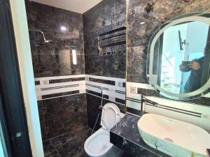 um banheiro com uma pia, um vaso sanitário e um espelho em Home 24 12 Đào Tấn em Hanói