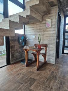 a room with a table with a fan and a staircase at Cabañas Litueche 2 in El Rosario