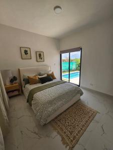 a bedroom with a bed and a large window at Modern House with Private Pool in Punta Cana in Punta Cana