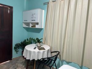 a table with a white table cloth and two chairs at Suíte Verde in Campo Grande