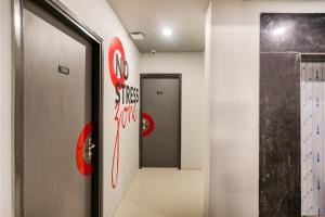a hallway with a door and a sign on the wall at Collection O Le Noida Hotel Near Sector 76 Metro Station in Noida