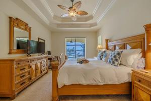 - une chambre avec un lit, une télévision et une commode dans l'établissement Palm Villa, à Shell Point Village 30 autres photos