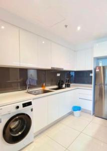 a white kitchen with a washing machine in it at Almas Suites Couple Sunrise Netflix 100mbps BySTAY in Nusajaya