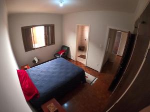 a bedroom with a blue bed and a living room at MR11 Guest House in Campinas