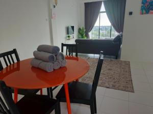 a table with towels on it in a living room at I&M Staycation in Alor Setar