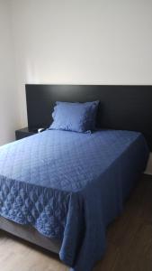un letto blu con un piumone blu e un cuscino di Casa de Praia, Piscina e Conforto no Frances a Marechal Deodoro