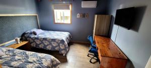 a room with two beds and a television in it at Cabaña ejecutiva in Río Bueno