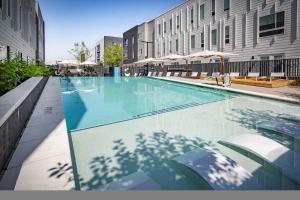 a large swimming pool in a city with buildings at CozySuites AYR in Indianapolis +18 photos