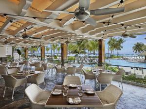 a restaurant with tables and chairs and a view of the ocean at Fairmont El San Juan Hotel in San Juan