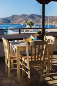een tafel en stoelen op een patio met uitzicht op de oceaan bij Grikos Hotel in Grikos