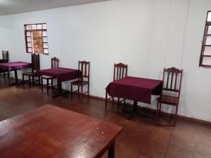 a group of tables and chairs in a room at Hotel paraiso in Jataí