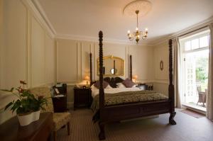 a bedroom with a canopy bed and a chandelier at Chateau La Chaire Hotel in Rozel