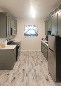 a kitchen with green cabinets and a wooden floor at Simon's casitas! in McGregor +7 photos