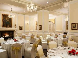 a banquet room with tables and chairs and a fireplace at Fairmont Le Manoir Richelieu in La Malbaie +75 photos