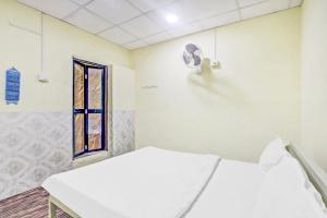 a hospital room with two beds and a window at Hotel O Radhe Krishna in Nagpur +38 photos