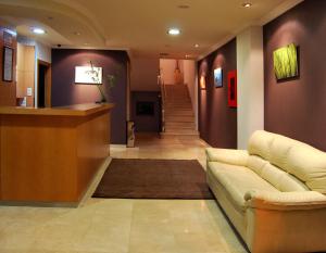 a lobby with a couch and a bar in a building at Hotel Plaza in Portonovo