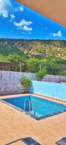 a swimming pool with a view of a hill at Girivan in Alwar
