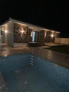 a house with a swimming pool at night at Girivan in Alwar