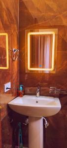 a bathroom with a white sink and a mirror at Girivan in Alwar