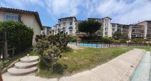 a large apartment complex with a swimming pool and a building at Bella vista al mar y cerca!! in El Quisco +5 photos