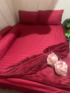 a bed with pink sheets and two roses on it at Pa Mali homestay in Ko Lipe