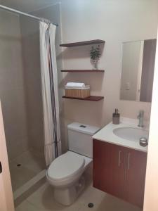 a bathroom with a toilet and a sink and a shower at Departamento con Vista al Mar in Lima